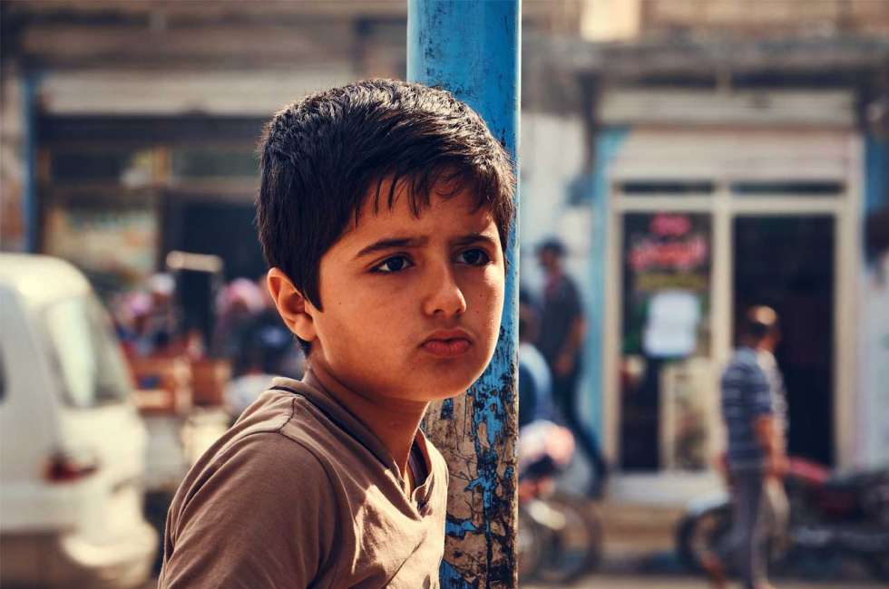 Skeptischer syrischer Junge vor der Kamera